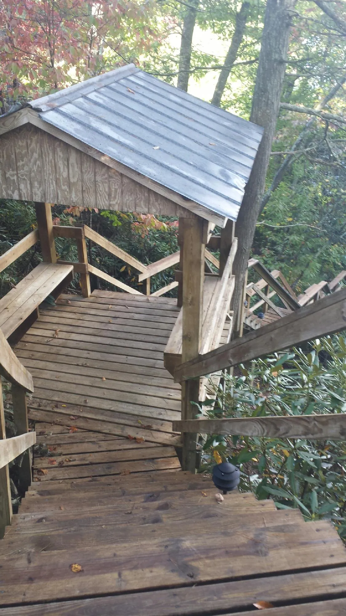 Metal roofed shelter over wooden steps on a wooded walkway — Skylight Repair & Installation work by our crew in Pompey