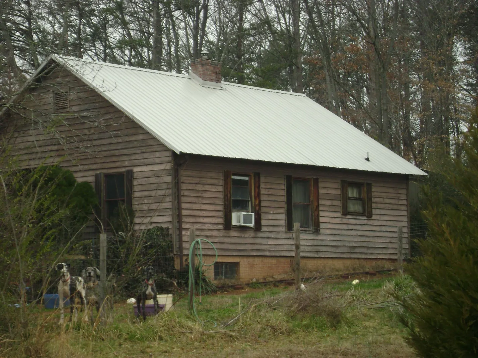 White metal roof on an old wood sided farmhouse, from a Metal Roof Installation job in Pompey