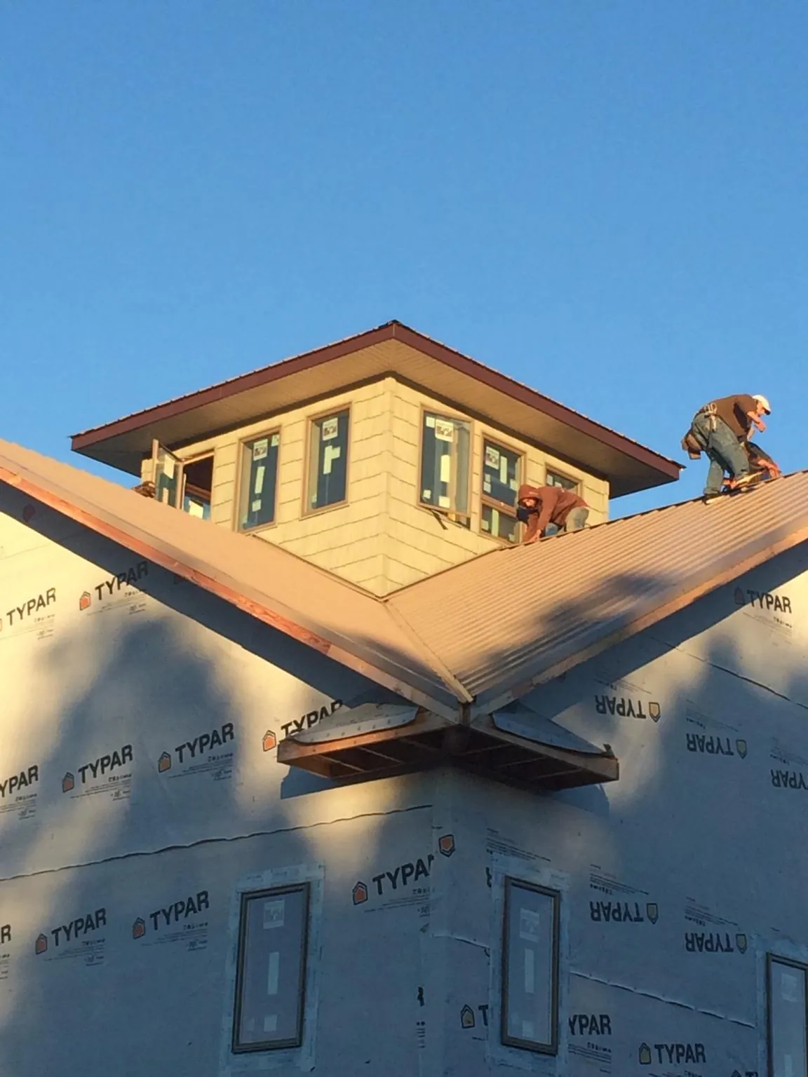 Roofers working around a rooftop cupola on a new metal roof at sunset — Roof Waterproofing in Pompey by Roofing Brothers